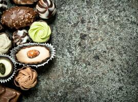 Chocolate candies. On rustic background. photo