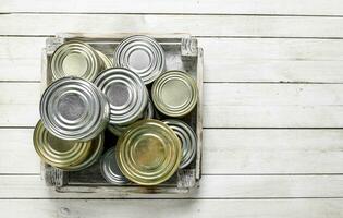 Tin cans with food in a box. photo