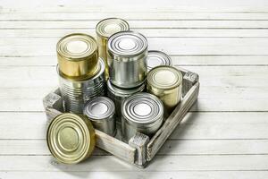 Tin cans with food in a box. photo