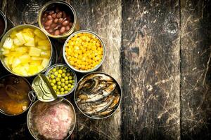 Various canned vegetables, meat, fish and fruits in tin cans. photo