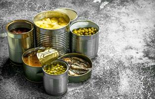 Various canned foods with meat, fish, vegetables and fruits in tin cans. photo