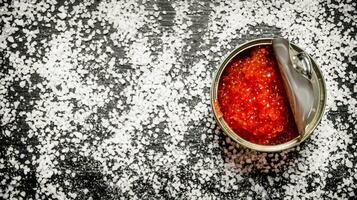 Red caviar in metal tin with salt.  Free space for text . photo