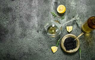 Black caviar with white wine and lemon. photo