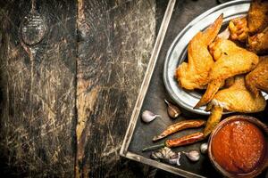 Smoked chicken wings with sauce. photo