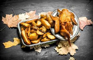 Smoked chicken wings with fried potatoes. photo