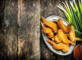 Smoked chicken wings with sauce. photo