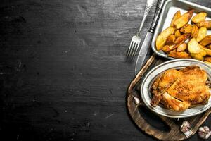 Fried chicken with potatoes on a tray. photo