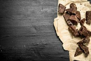 Chunks of chocolate on old paper. photo