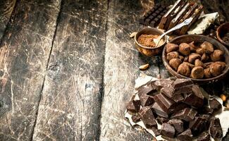 Different types of chocolate, cocoa powder and pieces of dark chocolate. photo