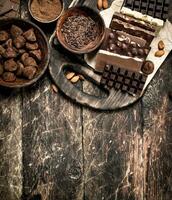 Chocolate bars with truffles and cocoa powder. photo