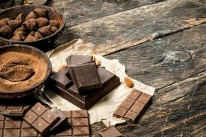 Chocolate bars with truffles and cocoa powder. photo