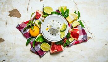 Juicer with citrus fruits - grapefruit, orange, tangerine, lemon, lime on the fabric. photo