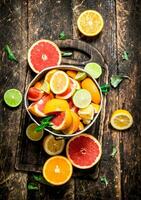 Citrus background. Fresh citrus fruits in the old bucket. photo