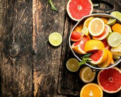 Citrus background. Fresh citrus fruits in the old bucket. photo