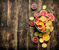 Citrus background. Fresh citrus fruits in the old bucket. photo