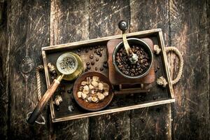 Fresh coffee with sugar and coffee beans on an old tray. photo