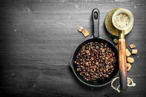 Fried coffee beans in a frying pan. photo