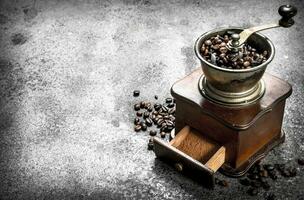 old hand-grinder with coffee beans. photo