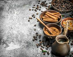 Fresh coffee in a clay turkey with crystals of sugar and cinnamon. photo