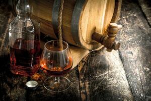 Cognac in a barrel with a glass. photo