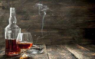 French cognac with a smoking cigar. photo