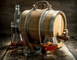 Barrel with French cognac, glasses and a cigar. photo