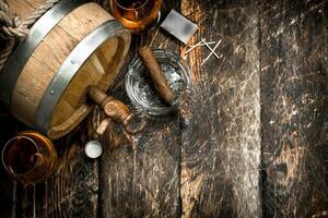 Barrel with French cognac, glasses and a cigar. photo