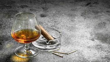 glass of cognac with a cigar. photo