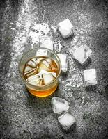 glass of whiskey with ice cubes. photo