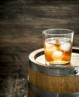 glass of Scotch whiskey with a barrel. photo