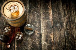 Whiskey background. A barrel of Scotch whiskey with glass and a cigar. photo