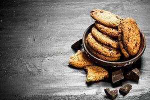 Oatmeal cookies in a bowl with chocolate. photo