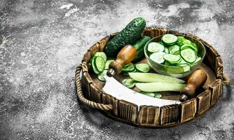 Fresh slices cucumbers on a wooden tray. photo
