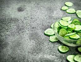 Slices of fresh cucumbers in a bowl. photo