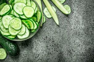 Slices of fresh cucumbers in a bowl. photo