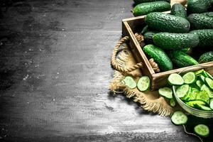 Fresh cucumbers in a wooden tray. photo