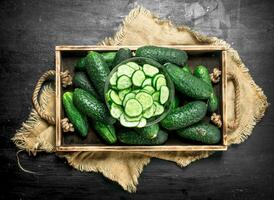 Fresh cucumbers in a wooden tray. photo