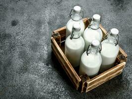Bottles of fresh milk in an old box. photo