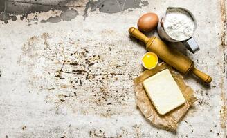 preparación de el masa. ingredientes para el masa - harina, huevos, mantequilla con un laminación alfiler. foto