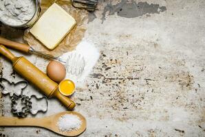 preparación de el masa. ingredientes para el masa - harina, huevos, mantequilla y diferente herramientas. foto