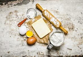 preparación de el masa. ingredientes para el masa - harina, huevos, mantequilla con un laminación alfiler. foto