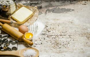 preparación de el masa. ingredientes para el masa - harina, huevos, mantequilla y diferente herramientas. foto