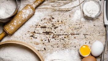 preparación de el masa. ingredientes para el masa - harina, huevos con un laminación alfiler, tamiz y batidor. foto