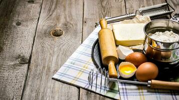 preparación de el masa. ingredientes para el masa - huevos, manteca, harina, sal y herramientas en el tela. foto