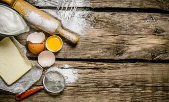 preparación de el masa. ingredientes para el masa - huevo, harina, mantequilla con un laminación alfiler . foto