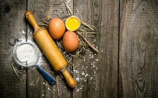 preparación de el masa. ingredientes para el masa huevos con harina y con un laminación alfiler. foto