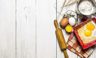 Baking background. Ingredients for the dough - Egg, flour and a rolling pin. photo