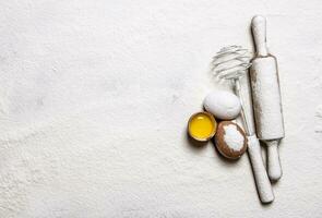 Eggs with venicom and rolling pin in flour.  Free space for text . photo