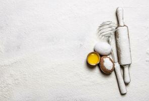 Eggs with venicom and rolling pin in flour.  Free space for text . photo