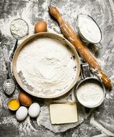 Preparation of the dough. Ingredients for the dough - Sieve flour, sour cream, butter, eggs with a rolling pin. photo